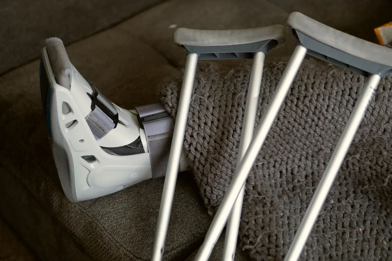 A walking boot and crutches beside a chair
